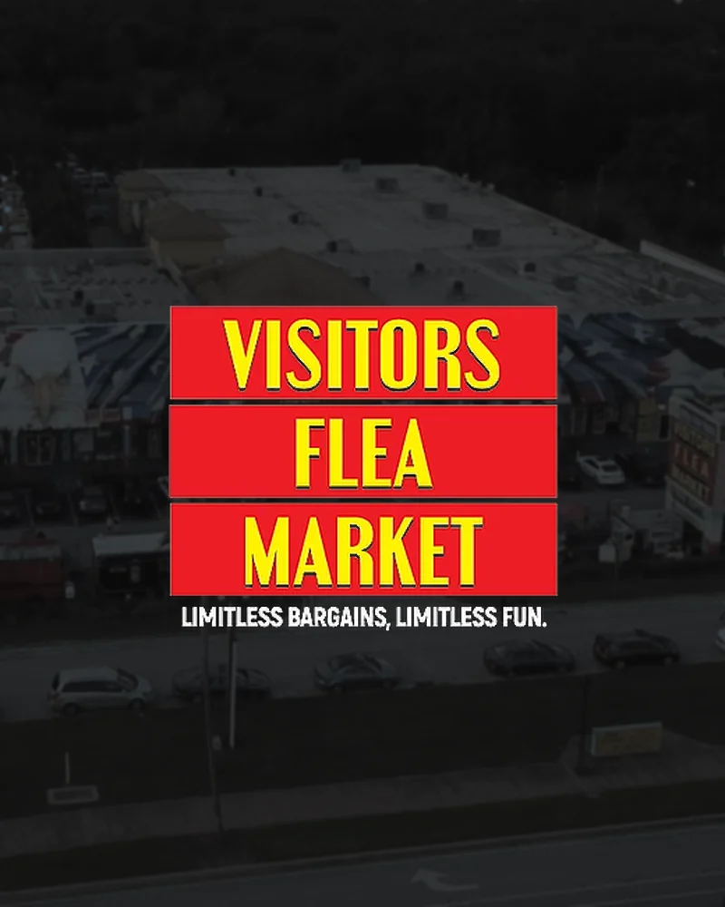 The plaza entrance arch, signed Visitors Market above World Food Trucks, with flags strung beneath it.